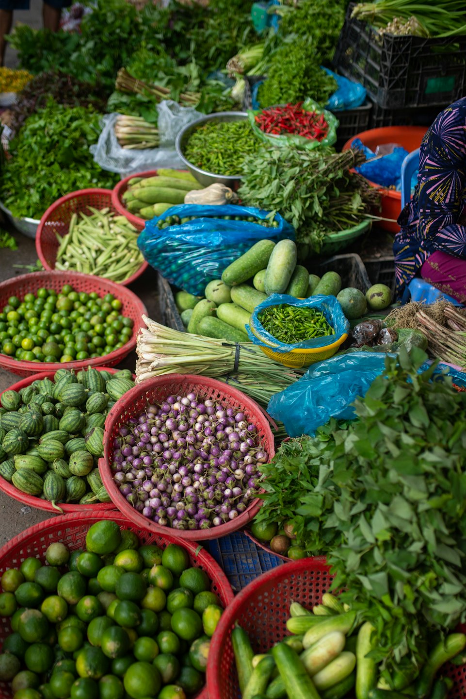Verdure fresche esposte in cesti in un mercato all'aperto.